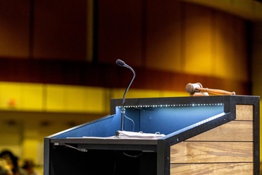 An up-close image of a podium at a conference center and a microphone.
