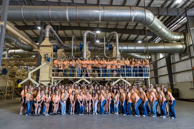 All attendees of the 2023 LEAD Conference posing for a group photo inside of a production plant at one of the tour stops.