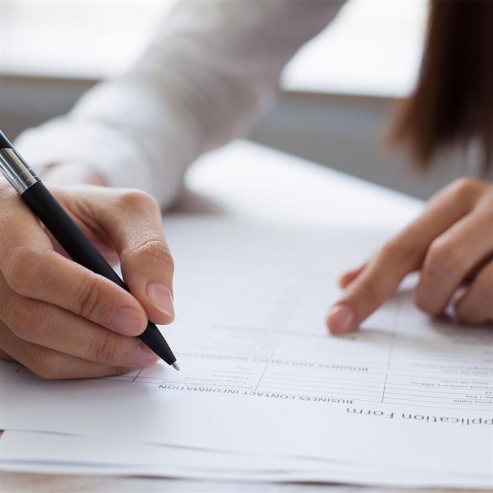 Person filling out paperwork.