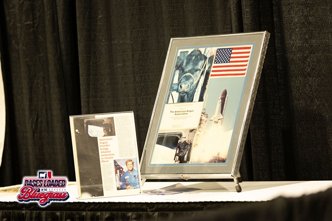 Framed American Angus Association and NASA memorabilia displayed as part of a silent auction exhibit.