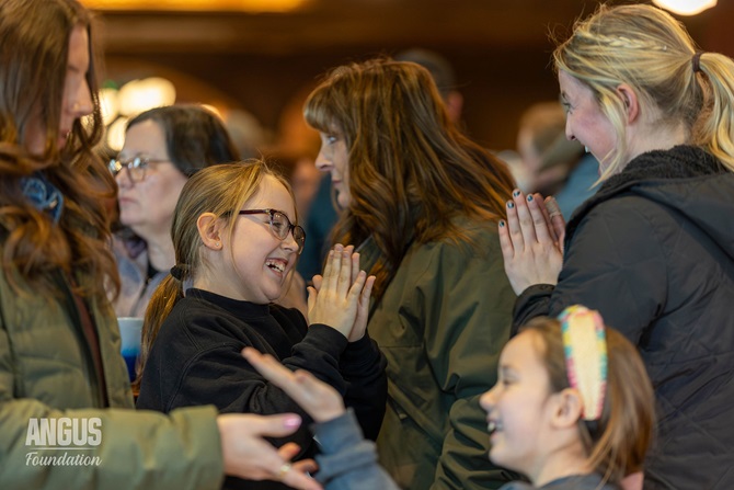 A young girl and an older friend celebrate together at the Angus Foundation NWSS Social.