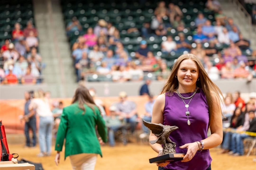 Lauren Wolter beams with joy while receiving the Jim Baldridge Outstanding Leadership Award at the National Junior Angus show in Tulsa, Oklahoma, on July 4th. 