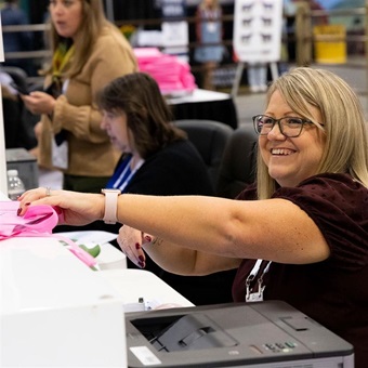 Angus team member helping check-in convention attendees at the registration booth. 