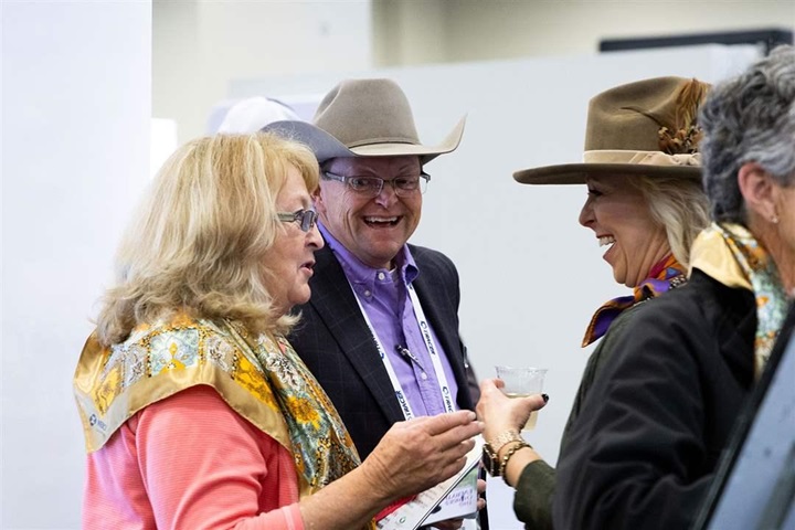 A group of women and men speaking together during a social hour at Angus Convention.