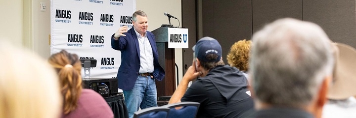 A speaker presenting at an Angus University session.
