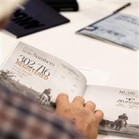 An individual flips through the Angus Annual Report.