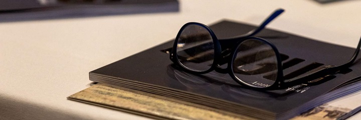 A pair of glasses setting atop a convention program.
