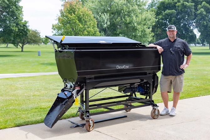 Individual standing next to large grill.