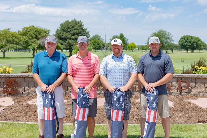 Group of four men on a golf tournament team.