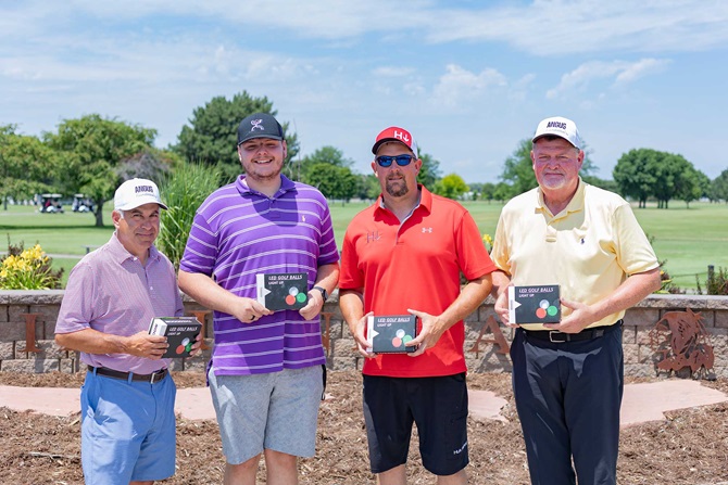 Group of four men on a golf tournament team.