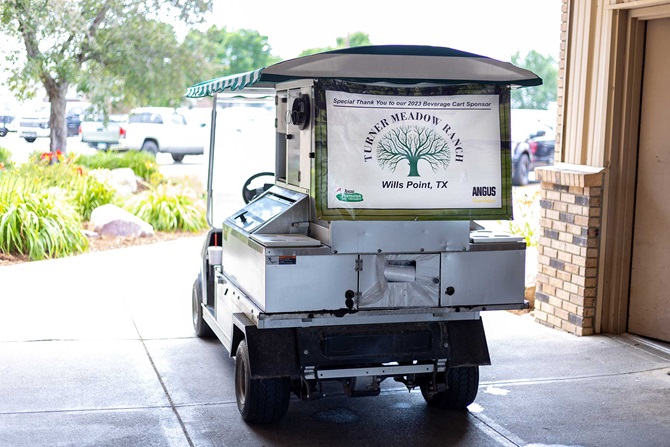 Back of golf cart with sponsorship banner attached.