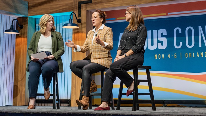 Three female panelists presenting to a group of attendees at Angus Convention.
