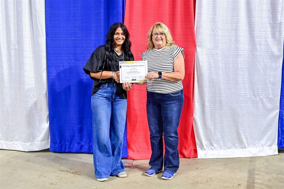 Addison Cotton of York, NE, accepts the Richard L. Spader Angus Foundation Scholarship from Sheri Spader at the National Junior Angus Show in Madison, WI. The Foundation awarded more than $388,500 in scholarships in 2024.