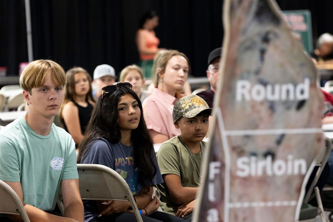 Luke Summers, Penelope Soto and Benjamin Soto listen intently to Gretchen Mafi, Oklahoma State University professor of animal and food science, present on meat quality during the 2025 National Junior Angus Show carcass clinic in Tulsa, Okla.