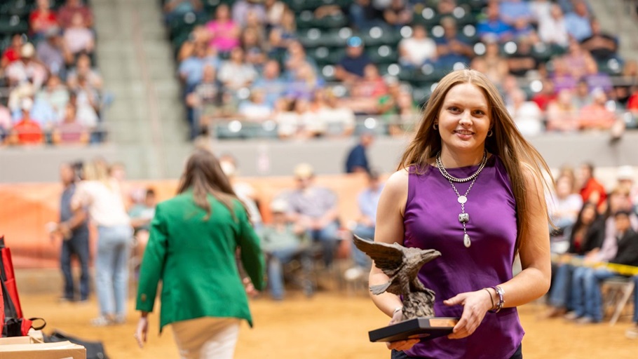 Lauren Wolter beams with joy while receiving the Jim Baldridge Outstanding Leadership Award at the National Junior Angus show in Tulsa, Oklahoma, on July 4th.