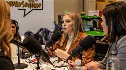 Four women sit around a table with microphones