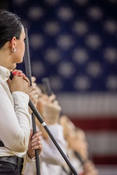 Young showmen with sticks. American flag in background.